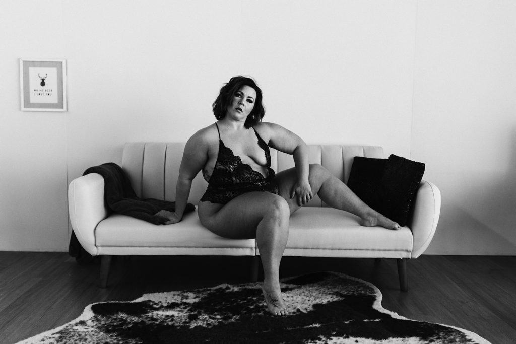 boudoir plus sized woman posing on couch