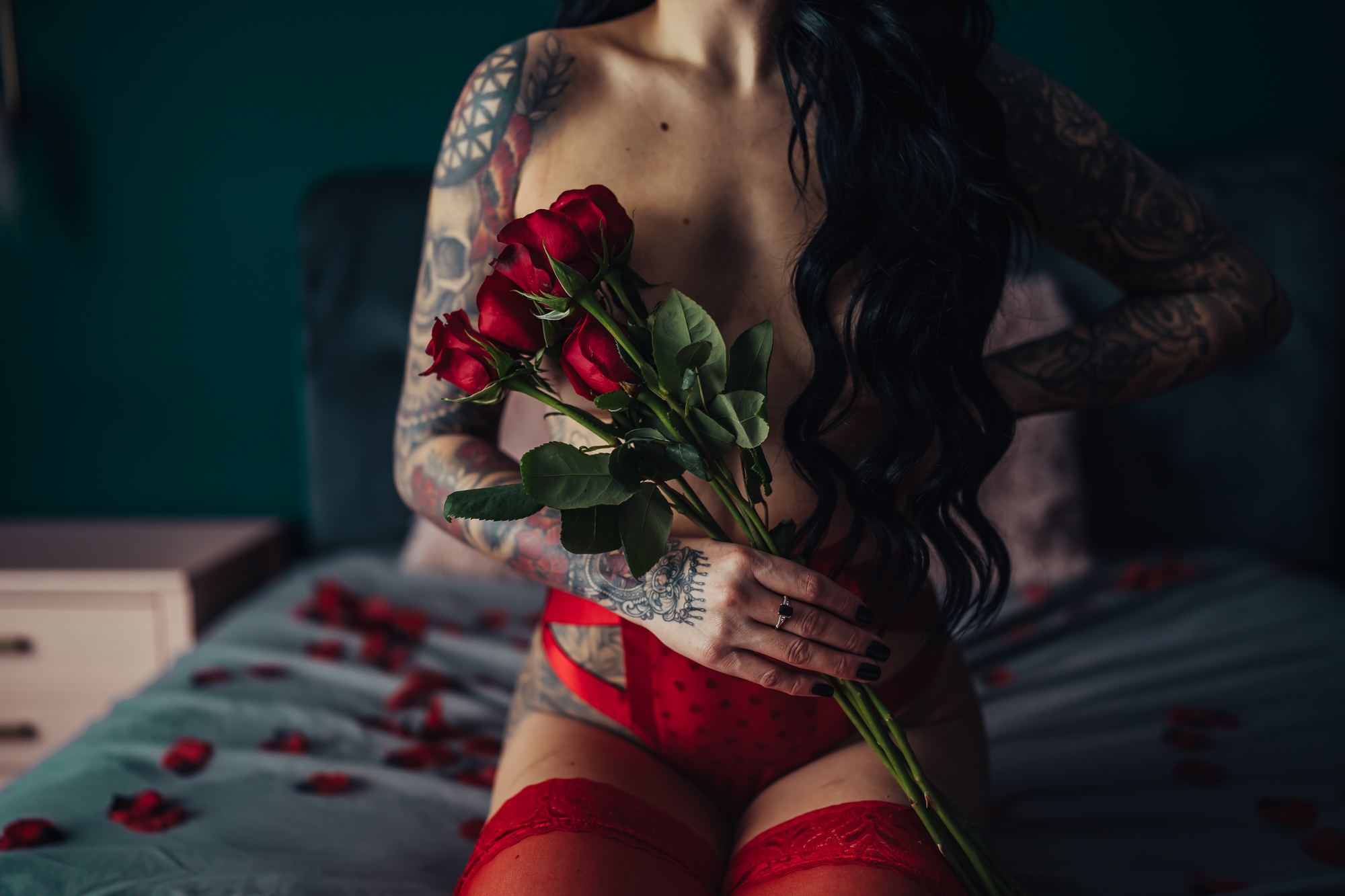 boudoir photo of woman in red lingerie holding red roses